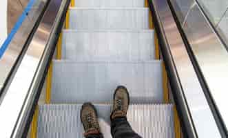 Foto grátis pés masculinos na escada rolante, vista superior.