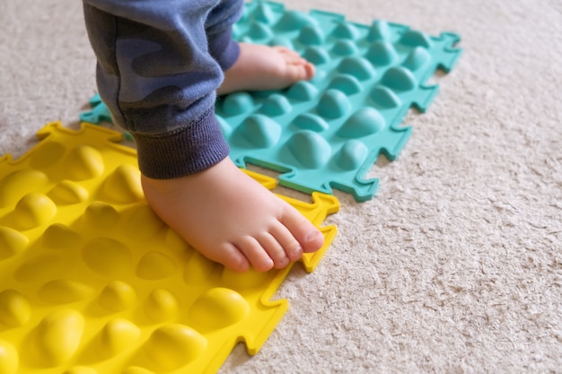 Pés pequenos de bebê no tapete com nervuras.