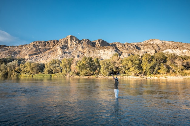 Foto grátis pesca masculina no lago com uma vara de pescar