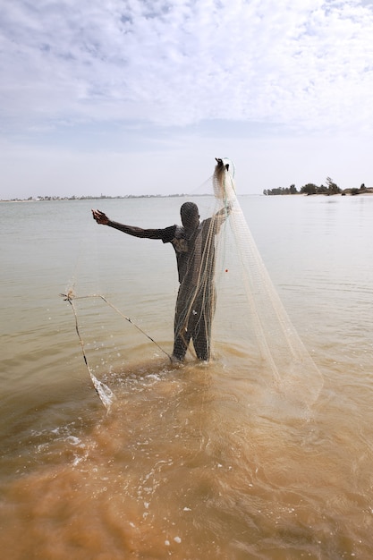 Pescador com rede no rio