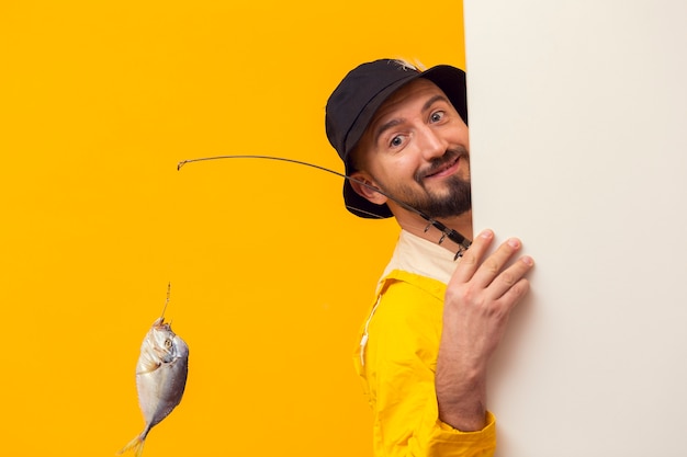 Pescador, segurando a vara de pescar e posando enquanto sorrindo