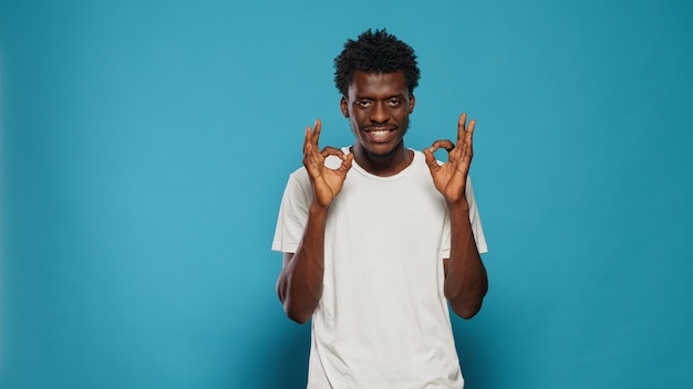 Pessoa alegre fazendo símbolo bem com as mãos. jovem mostrando sinal com as palmas das mãos e os dedos expressando aprovação e acordo com o gesto. adulto casual com atitude positiva sorrindo