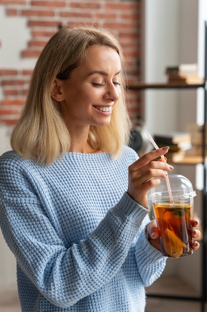 Pessoa bebendo kombucha em casa na cozinha