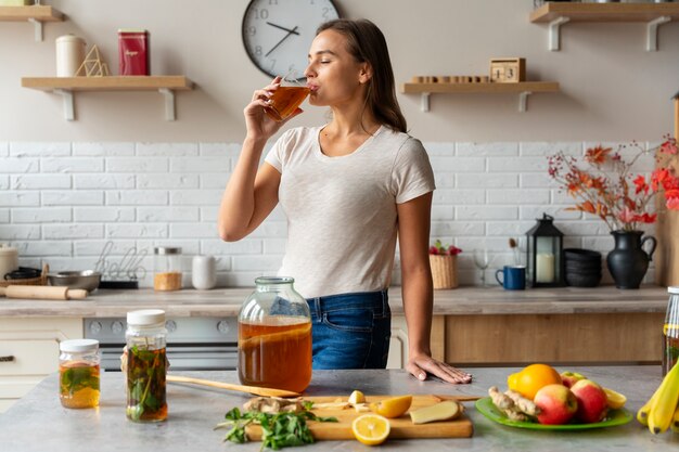 Pessoa bebendo kombucha em casa na cozinha