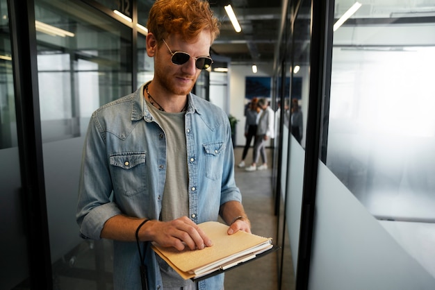 Foto grátis pessoa cega trabalhando em um trabalho de escritório inclusivo