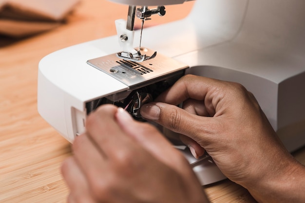 Pessoa colocando linha em uma máquina de costura