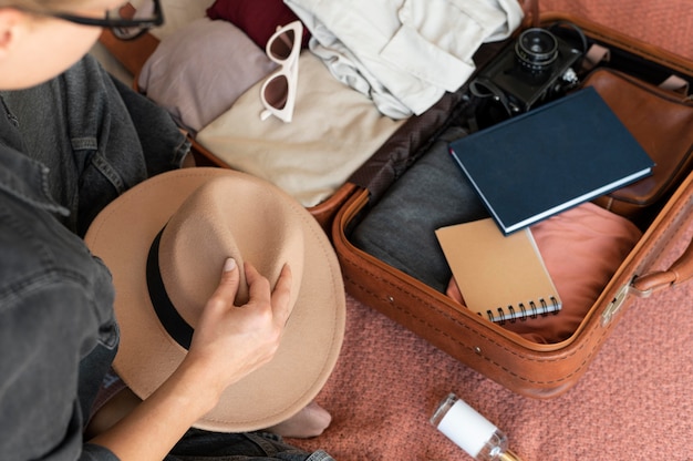 Pessoa colocando roupas em uma mala para as férias