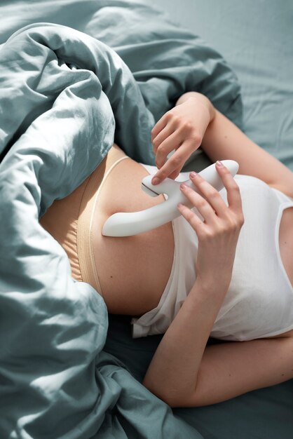 Pessoa com brinquedo sexual na cama