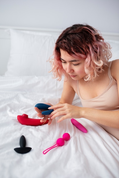 Foto grátis pessoa com brinquedo sexual na cama