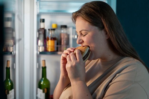 Pessoa com distúrbio alimentar a tentar comer fast food