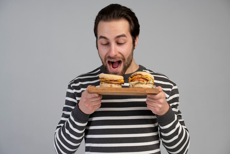 Foto grátis pessoa com distúrbio alimentar a tentar comer fast food