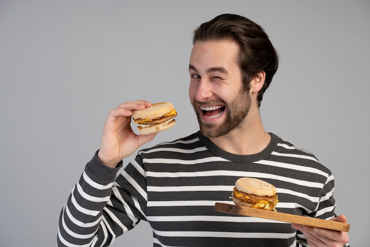 Foto grátis pessoa com distúrbio alimentar a tentar comer fast food