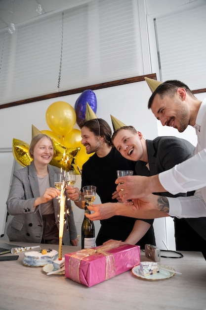 Foto grátis pessoa comemorando aniversário no escritório