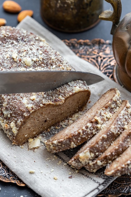 Pessoa cortando pão vegano cru com uma faca