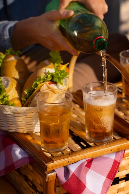 Pessoa derramando bebida de guaraná em copo de garrafa