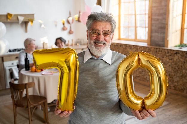 Foto grátis pessoa idosa comemorando com balões