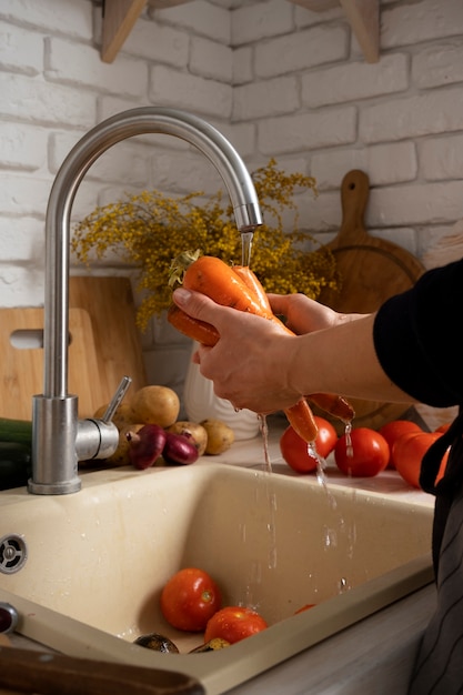 Pessoa lavando cenouras na cozinha