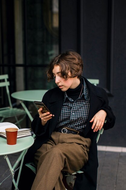 Pessoa não binária verificando um telefone