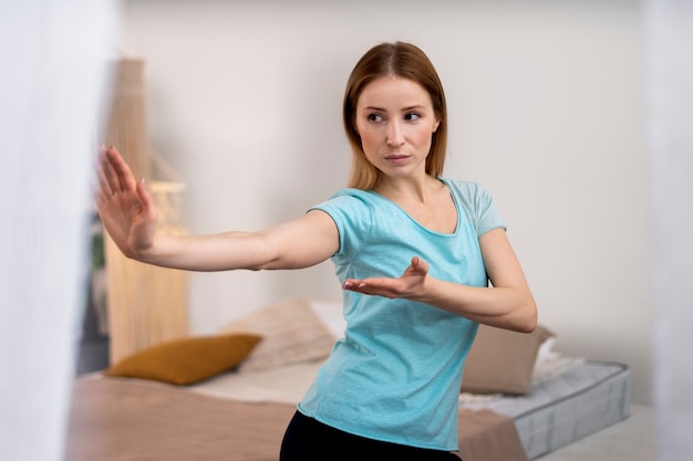 Foto grátis pessoa praticando tai chi dentro de casa