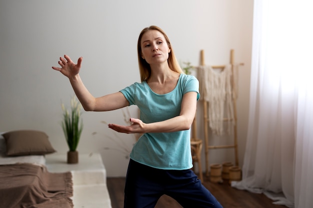 Foto grátis pessoa praticando tai chi dentro de casa