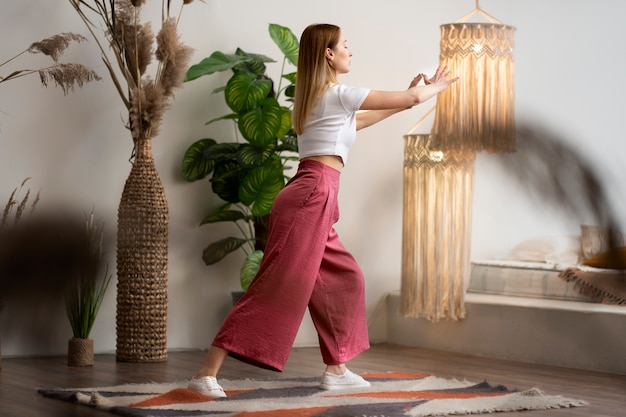 Foto grátis pessoa praticando tai chi dentro de casa