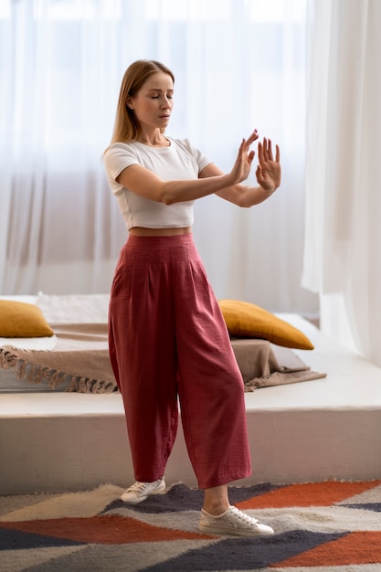 Foto grátis pessoa praticando tai chi dentro de casa