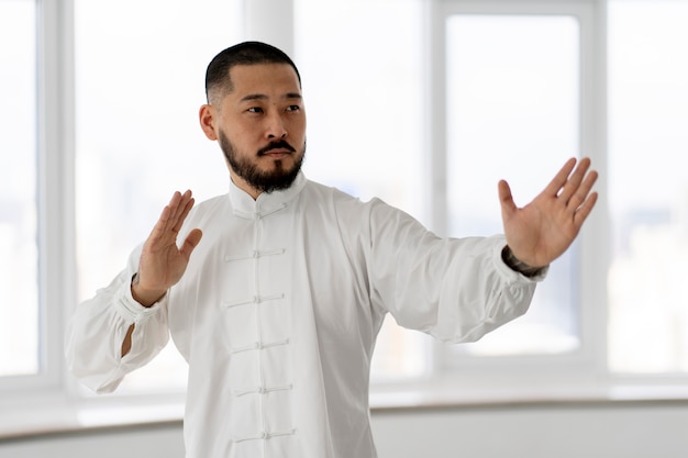 Foto grátis pessoa praticando tai chi dentro de casa