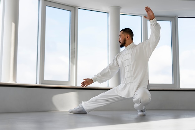 Foto grátis pessoa praticando tai chi dentro de casa