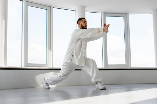 Pessoa praticando tai chi dentro de casa