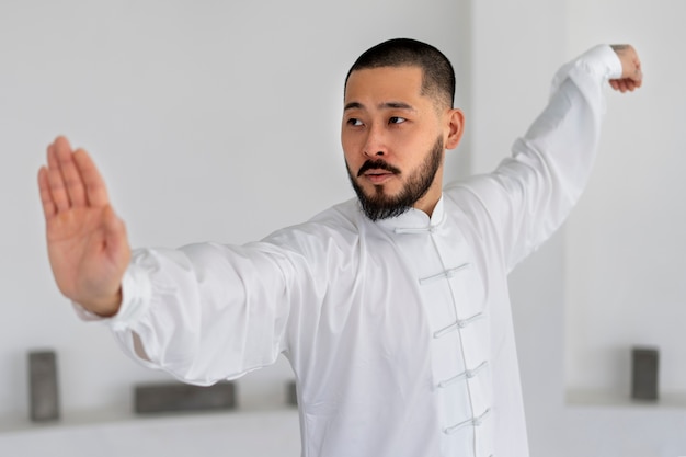 Foto grátis pessoa praticando tai chi dentro de casa