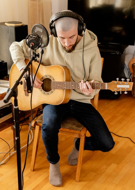 Foto grátis pessoa produzindo música dentro de casa