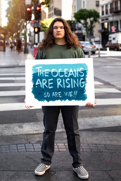 Pessoa protestando com cartaz para o dia mundial do meio ambiente ao ar livre