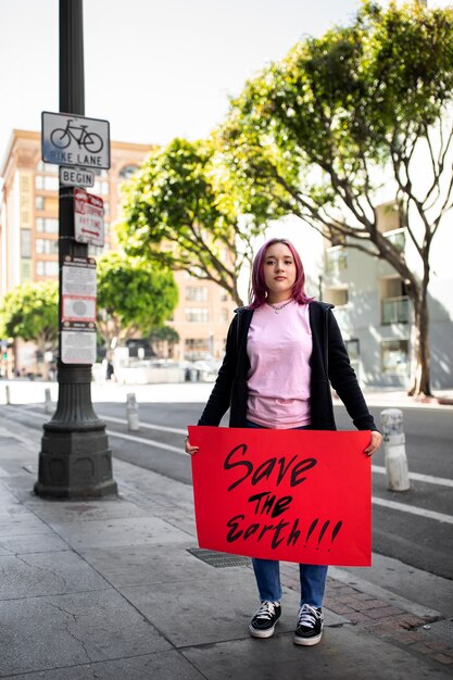 Pessoa protestando com cartaz para o dia mundial do meio ambiente ao ar livre