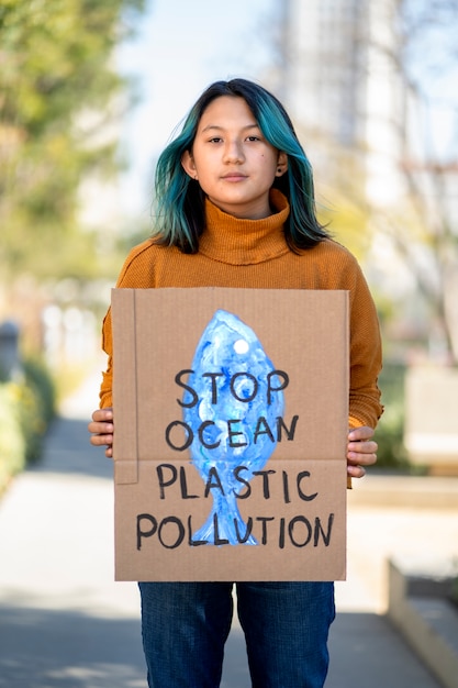 Pessoa protestando com cartaz para o dia mundial do meio ambiente ao ar livre