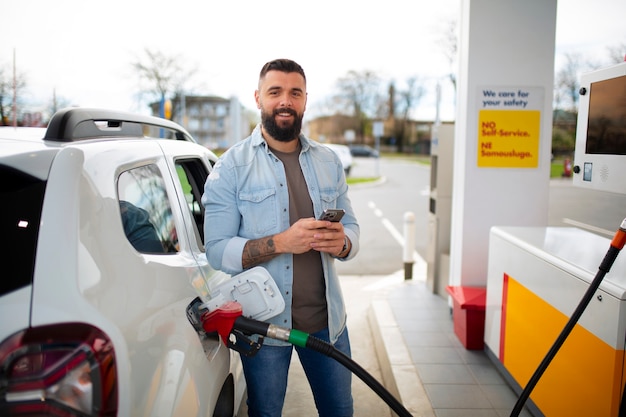 Foto grátis pessoa que passa o tempo no posto de gasolina