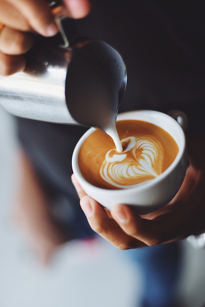 Pessoa que serve uma xícara de café