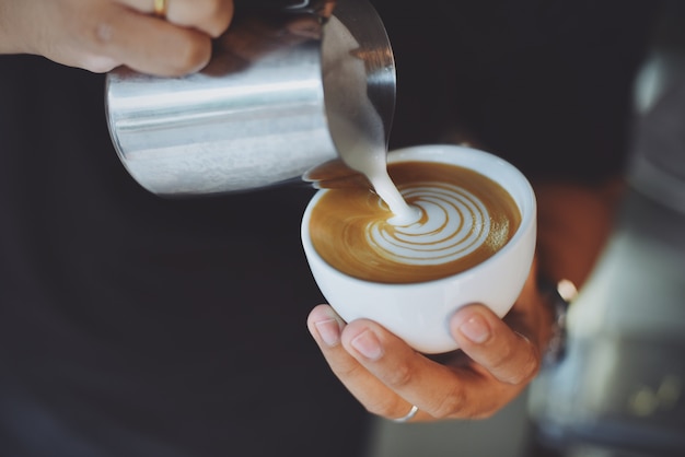 Pessoa que serve uma xícara de café