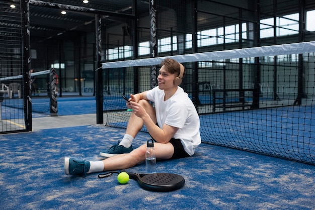 Pessoa se preparando para jogar padel dentro