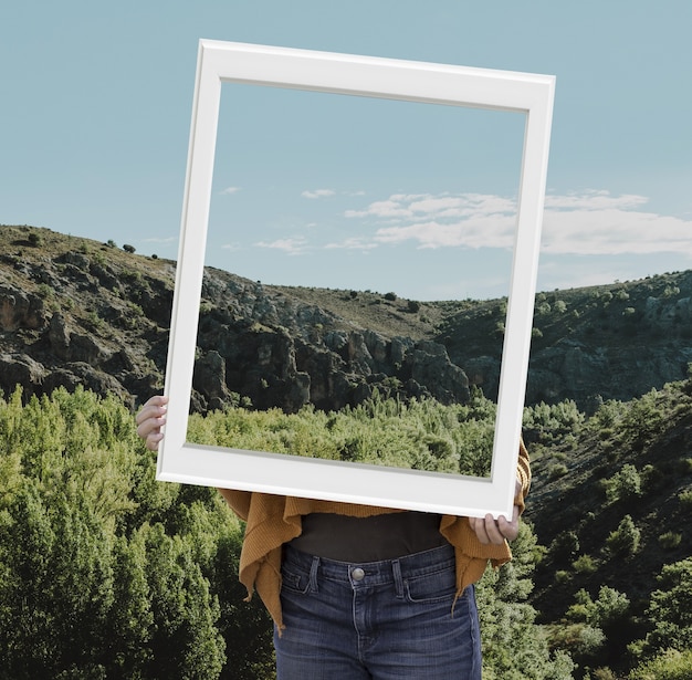 Foto grátis pessoa segurando quadro com conceito de paisagem de natureza aberta