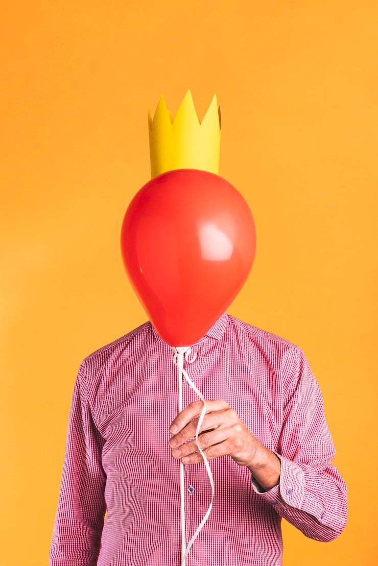 Foto grátis pessoa, segurando um balão em fundo laranja