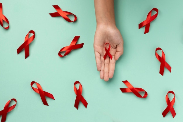 Foto grátis pessoa segurando um símbolo de fita do dia mundial da aids