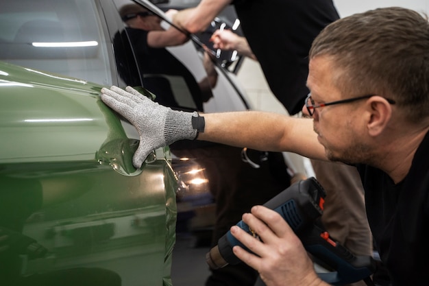 Foto grátis pessoa trabalhando no envelopamento de carros