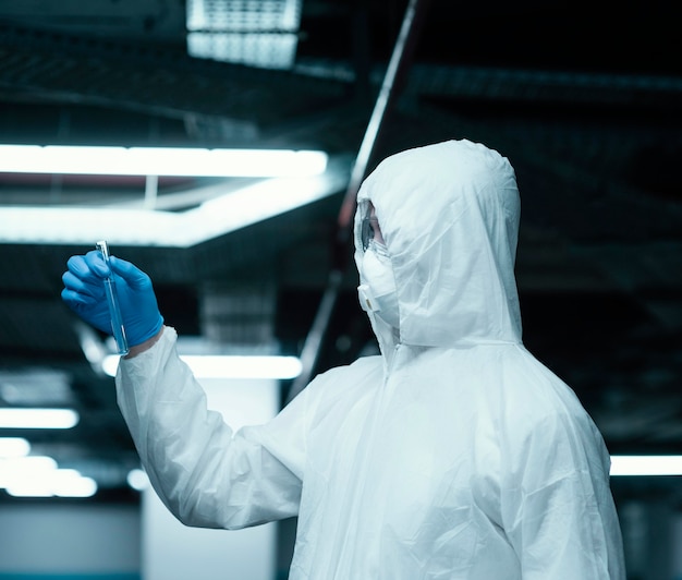 Foto grátis pessoa vestindo um traje de prevenção e colhendo amostras