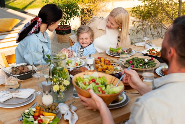 Pessoas à mesa com comida saborosa fecham