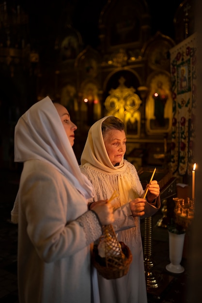 Foto grátis pessoas acendendo velas na igreja em comemoração à páscoa grega