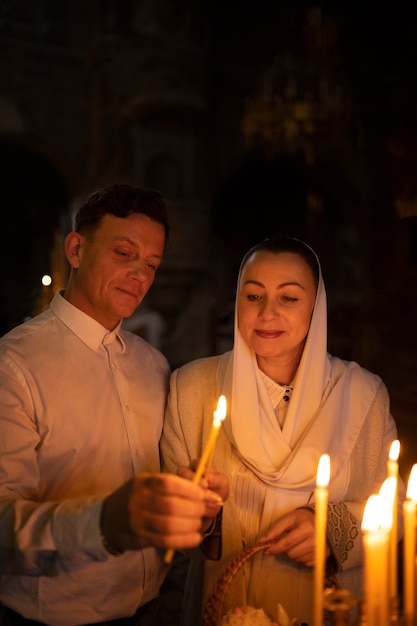 Foto grátis pessoas acendendo velas na igreja em comemoração à páscoa grega