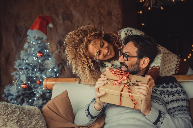 Pessoas adultas felizes em casa com presentes e decorações de natal
