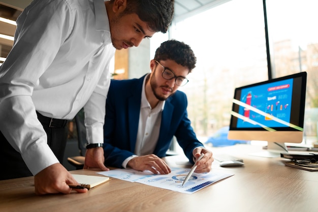 Foto grátis pessoas analisando e verificando gráficos financeiros no escritório