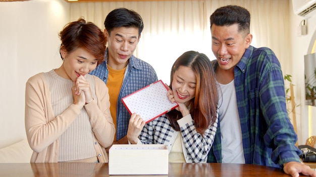 Pessoas asiáticas mostrando presentes para feliz ano novo em casa cumprimentando amigos em videochamada remota