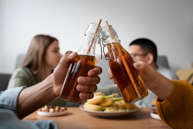 Foto grátis pessoas bebendo kombucha em uma reunião